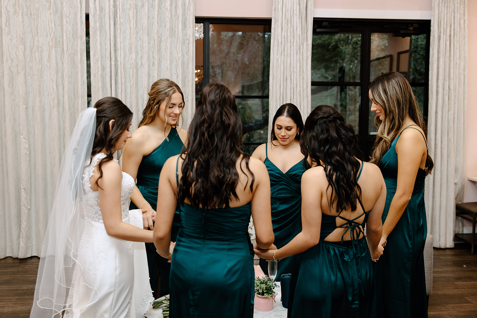 Bride and her bridesmaids praying before the ceremony