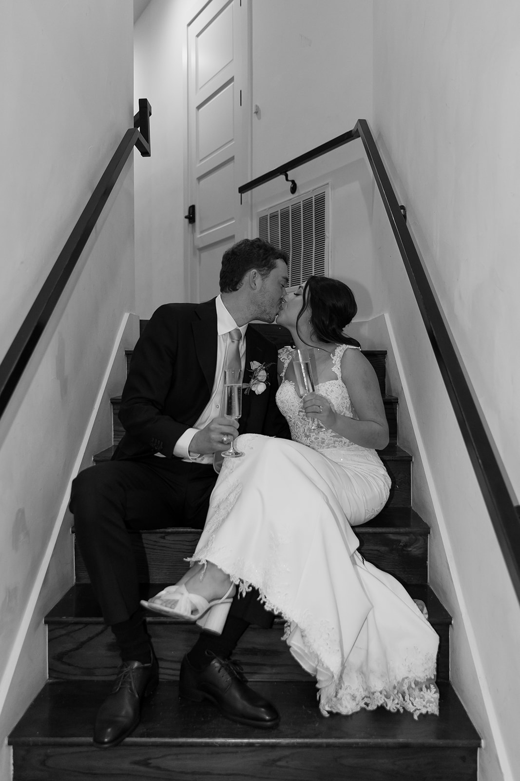 Bride and groom sitting on steps with champagne