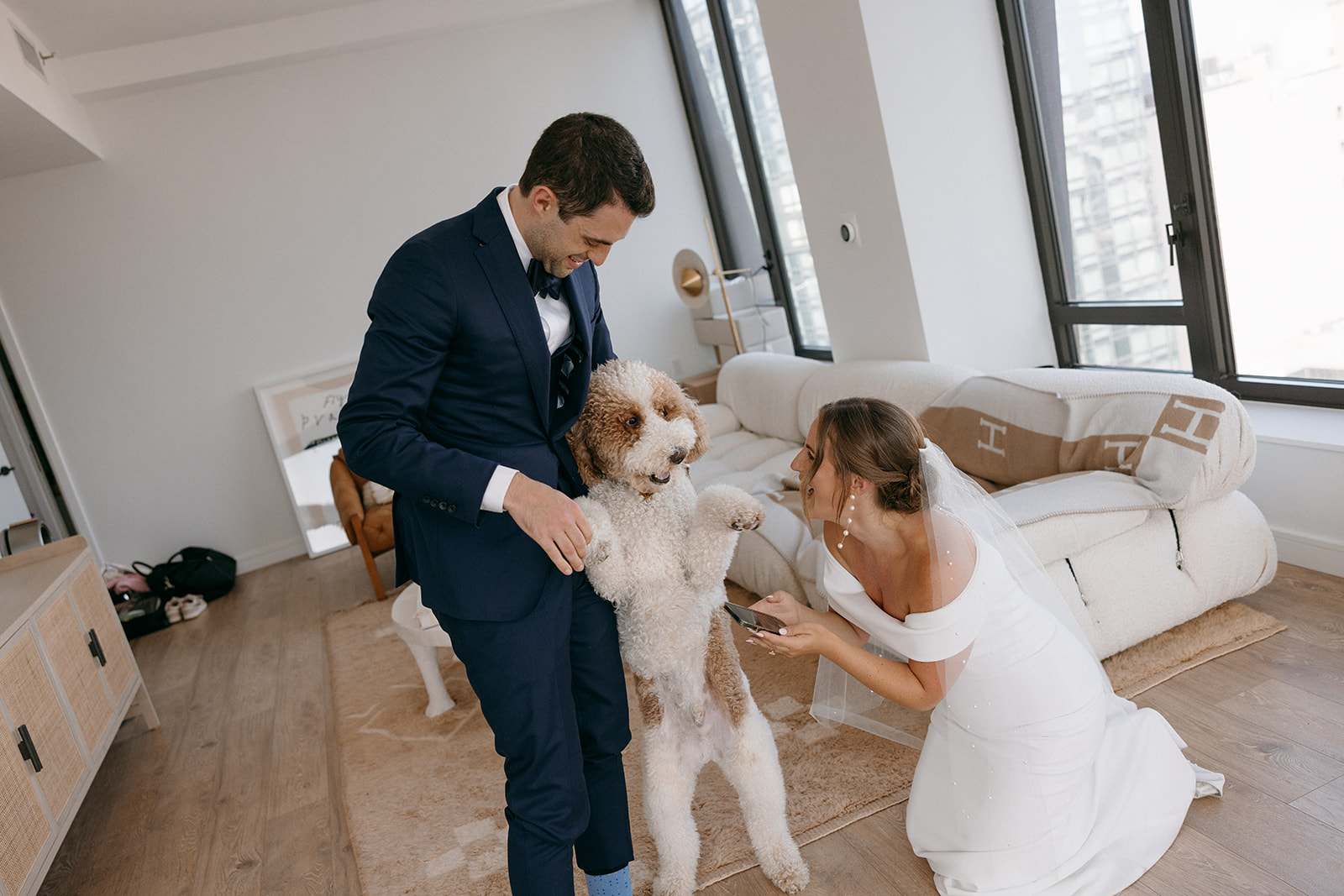 A bride and groom smiles with their dog during their wedding day in NYC