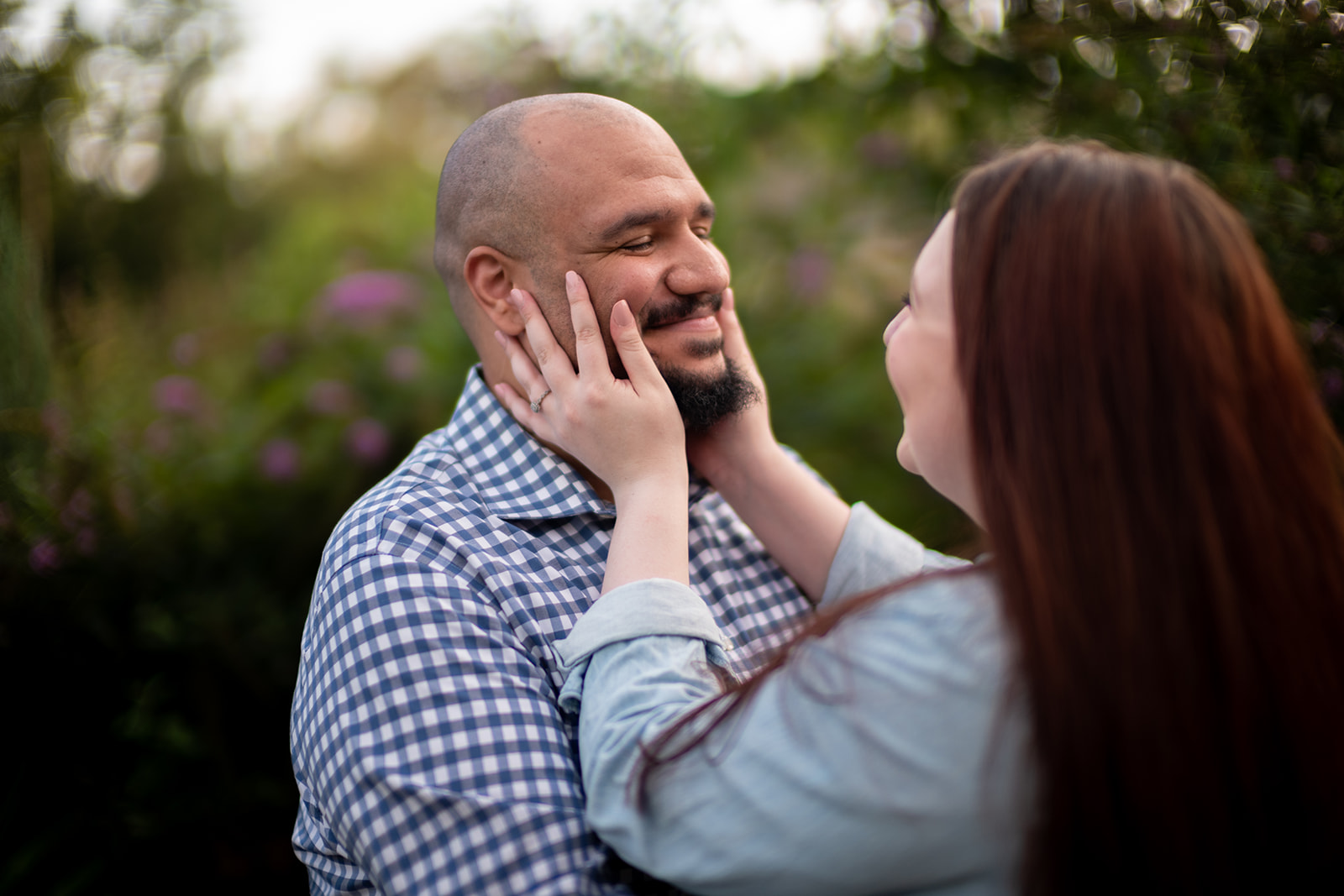 Engaged couple laughing during outdoor photo session in Scranton park, capturing natural and candid moments.