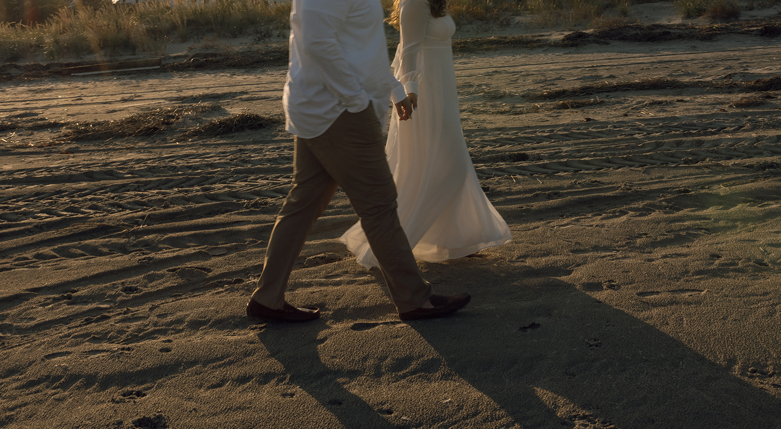 A couple holds each other during their engagement session in New Jersey on the beach