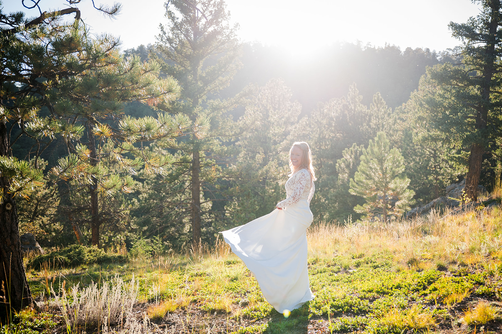 The bride twirls her dress with the sun setting during golden hour behind her.