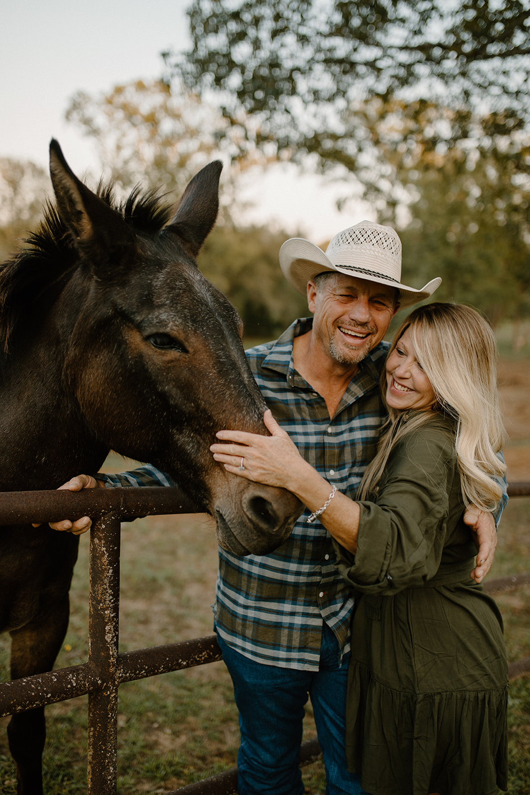 Couple laughing candidly during their backyard engagement session in Crockett, East Texas.