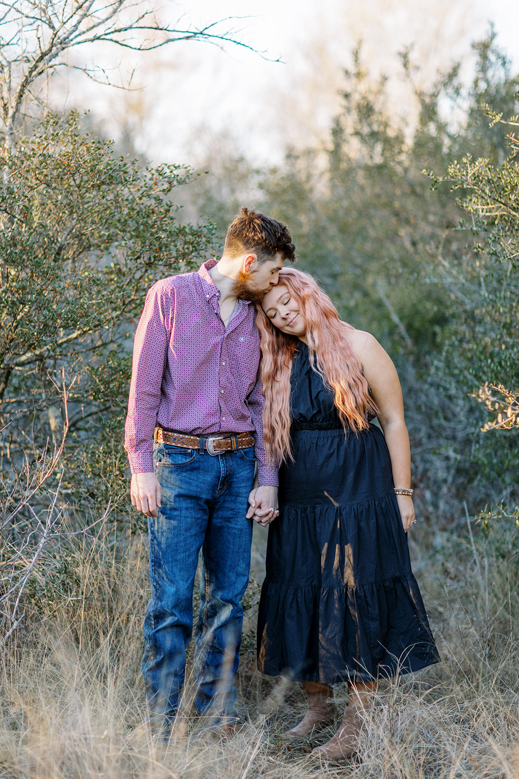 couple posing in a field for an engagement session in College Station