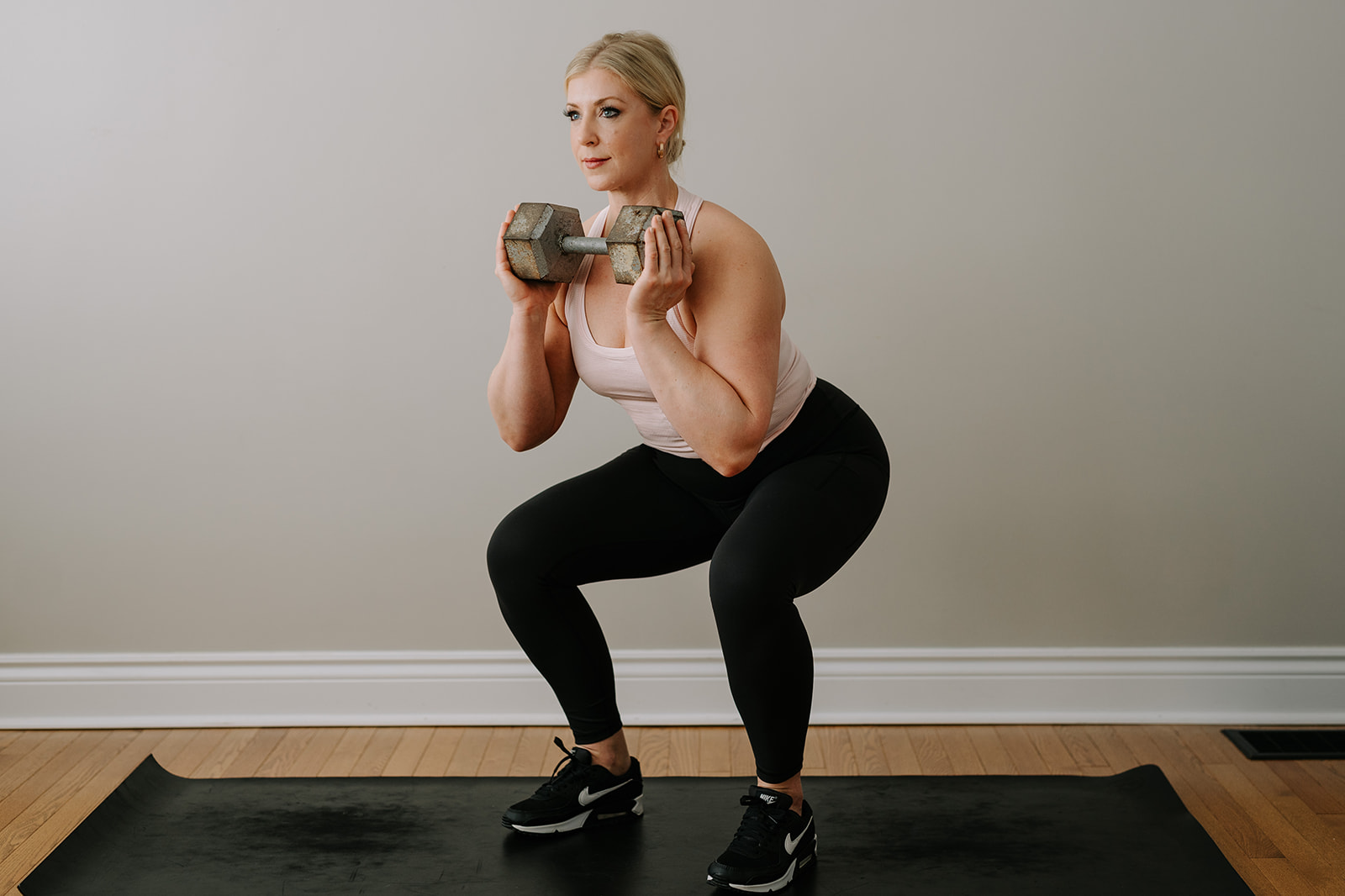 personal trainer squatting 