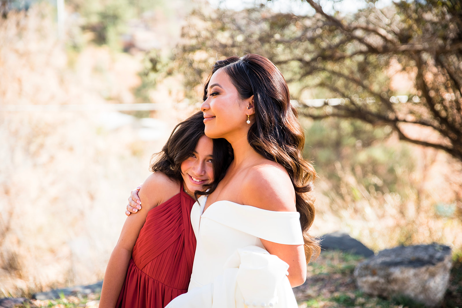 The bride hugs her preteen daughter after an emotional first look on her wedding day.