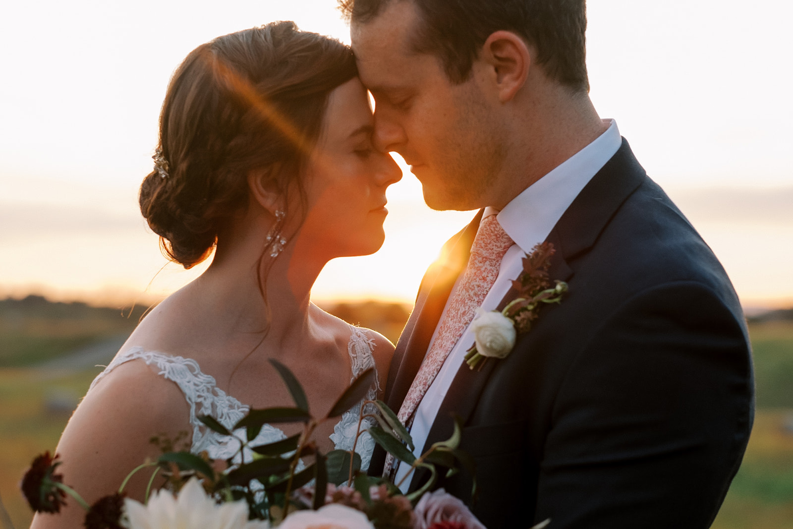 Bride and groom hold each other close at sunset at Goodstone wedding