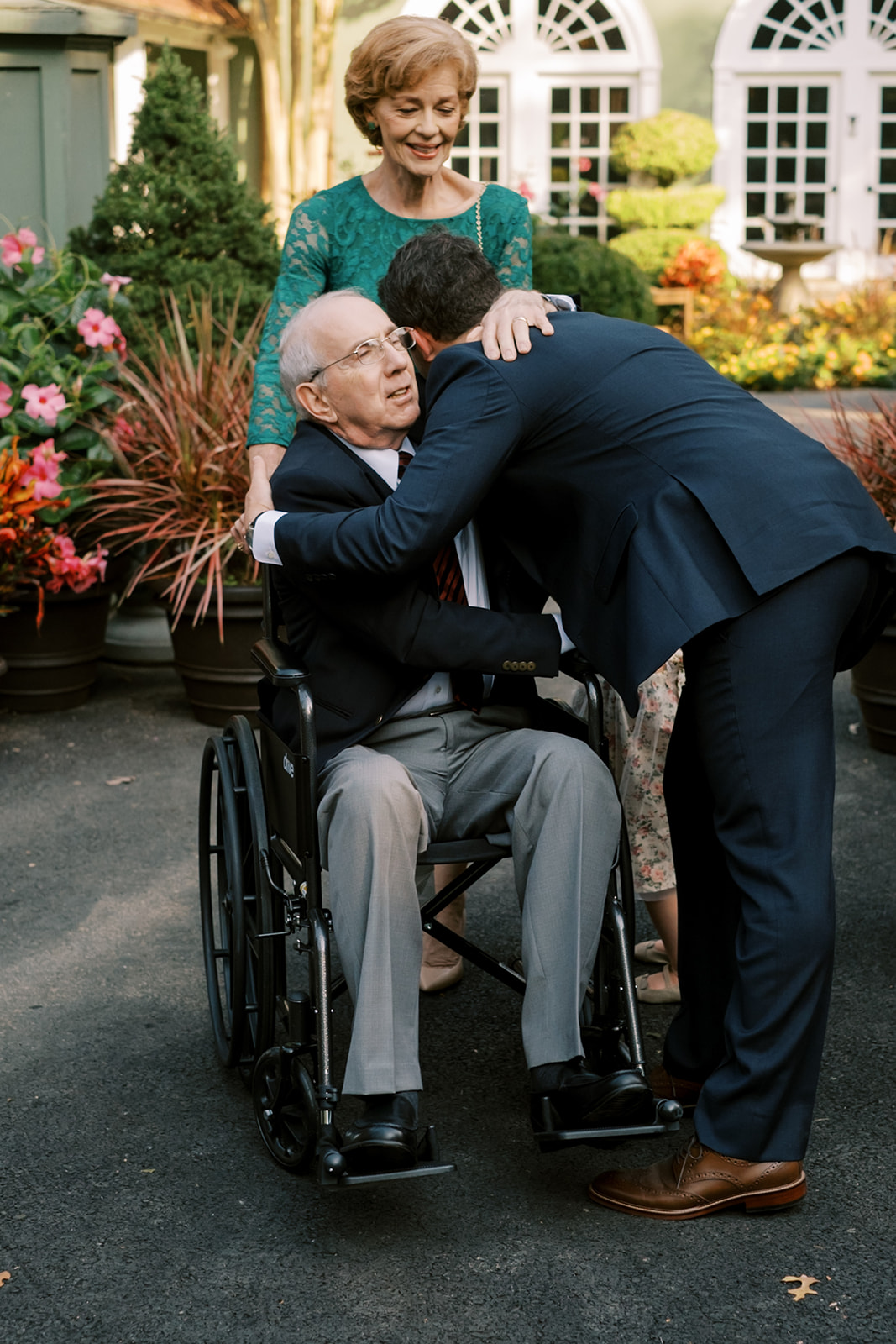 Groom hugging grandfather in a wheelchair before the wedding ceremony