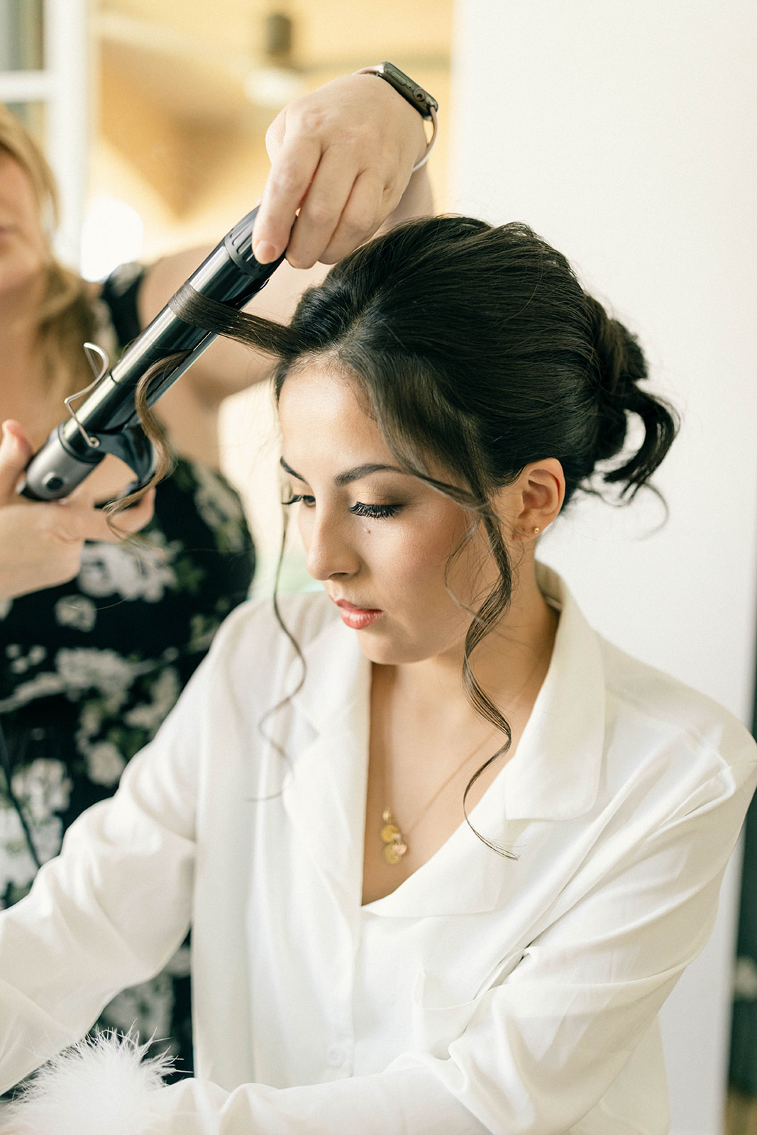 Bride gets hair done before intimate beach ceremony while writing her vows