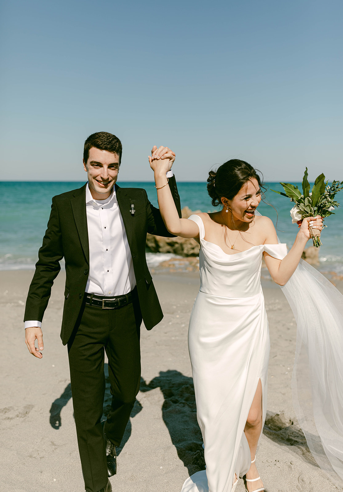 Bride and Groom cheer as they walk back down the aisle of their intimate beach wedding in Palm Beach, Florida
