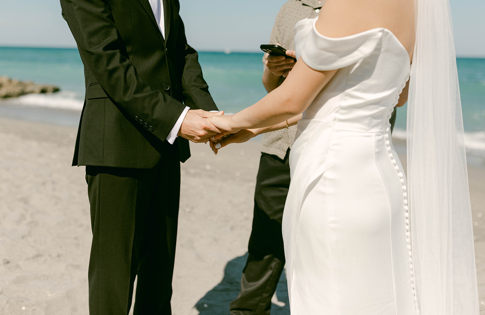 Bride and Groom hold hands during intimate beach ceremony in Palm Beach, Florida