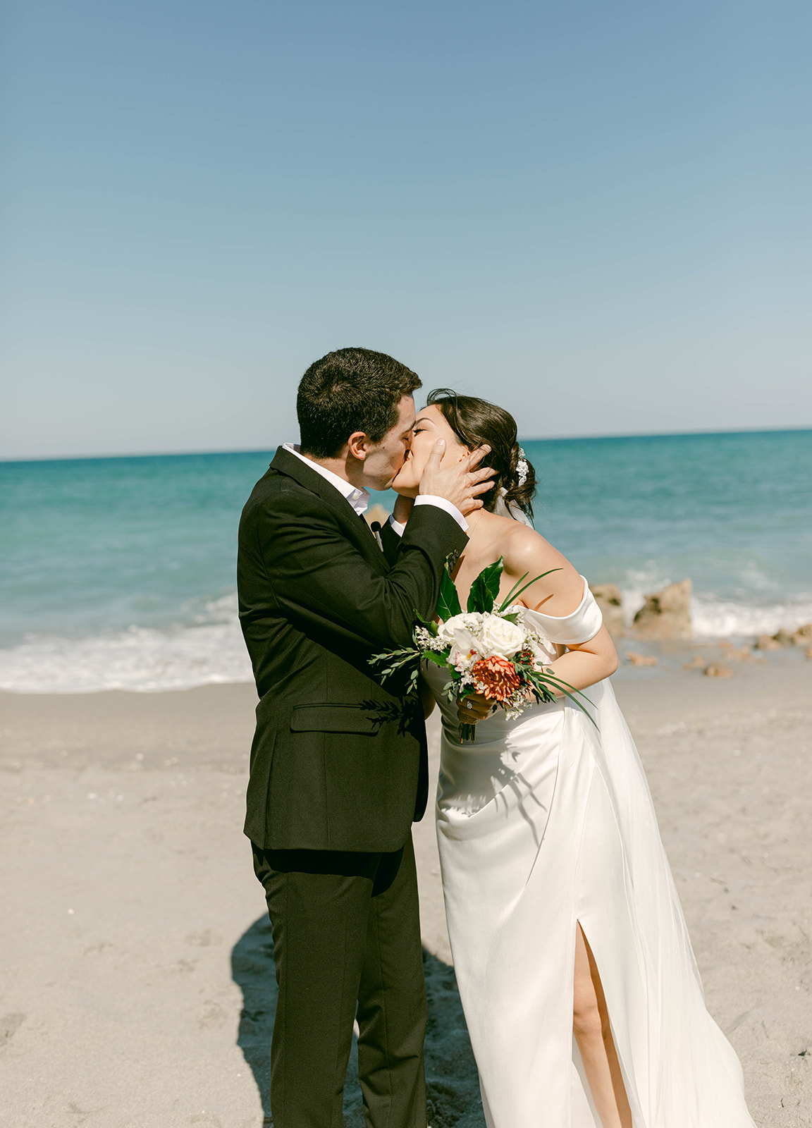 Bride and Groom share their first kiss in intimate Palm Beach, Florida wedding on the beach