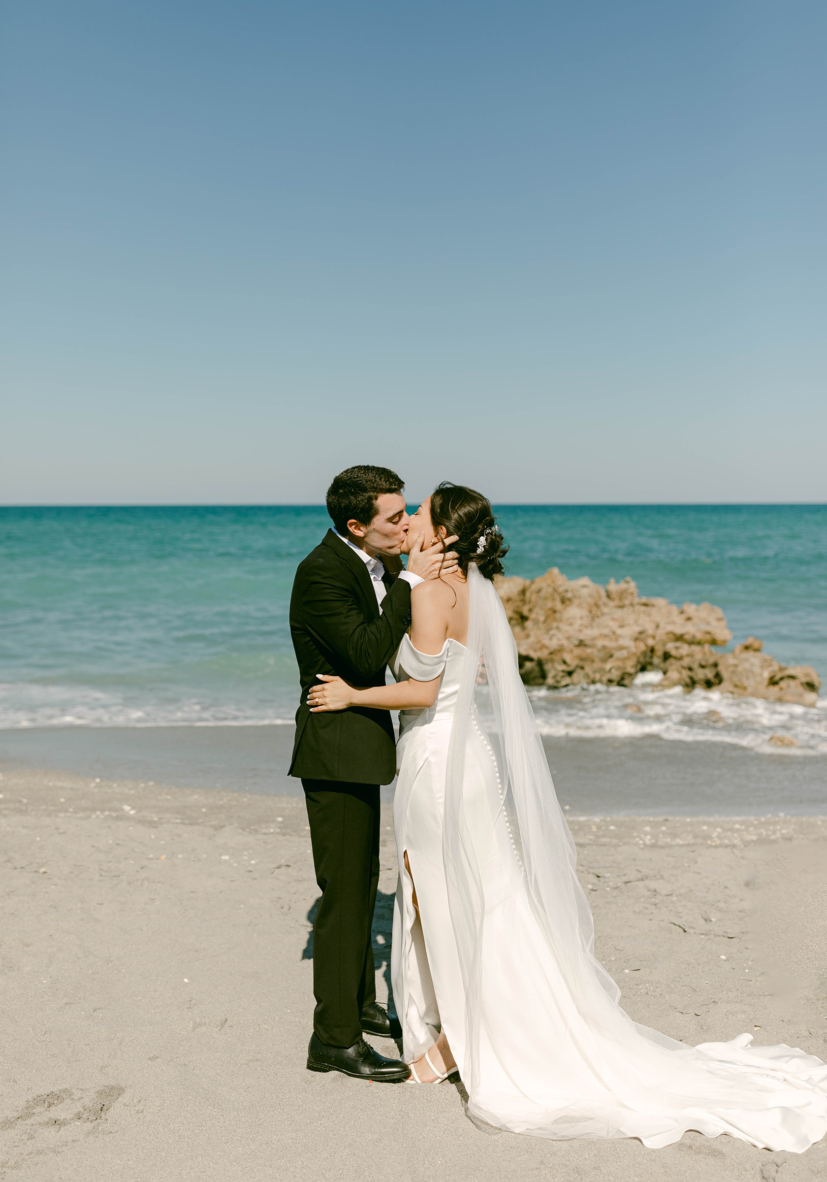 Couple shares first kiss on the beach in Palm Beach following their intimate wedding ceremony