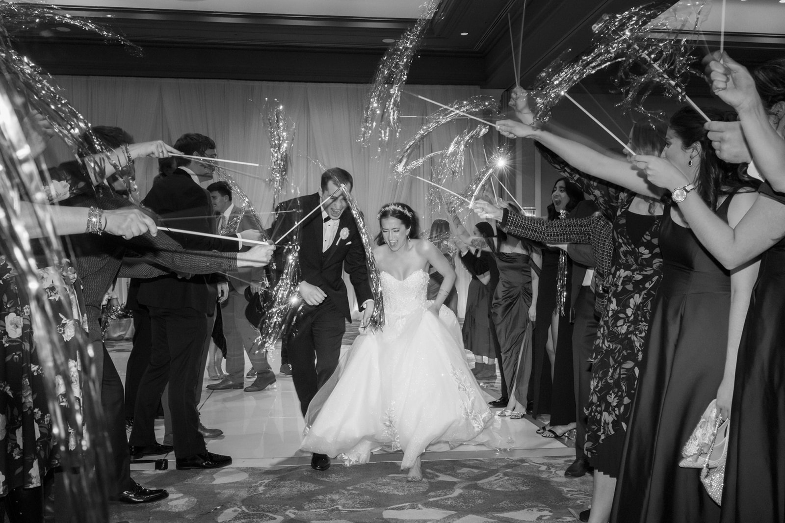 bride and groom run through streamers to exit Lansdowne Virginia wedding