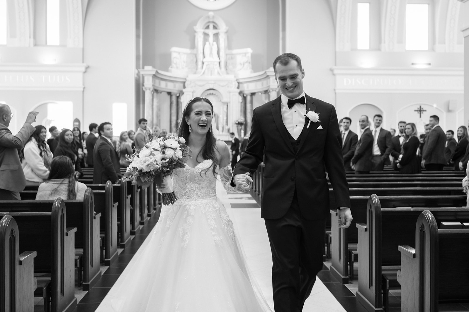 Bride and groom walking up St John's church aisle as husband and wife.