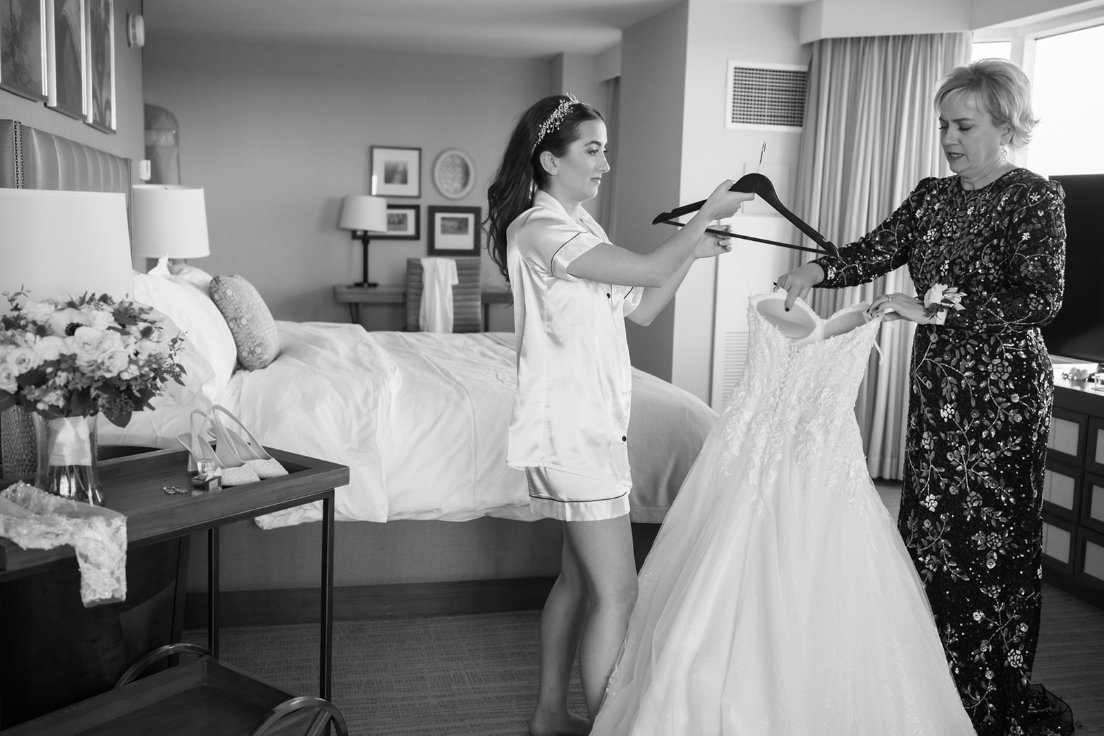 Bride's mom helping her put on wedding dress at Lansdowne Resort for Virginia wedding