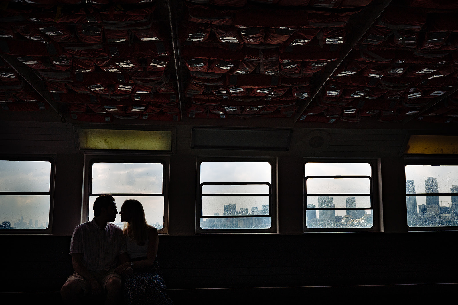 Couple kiss on a ferry to Toronto island during their engagement session 