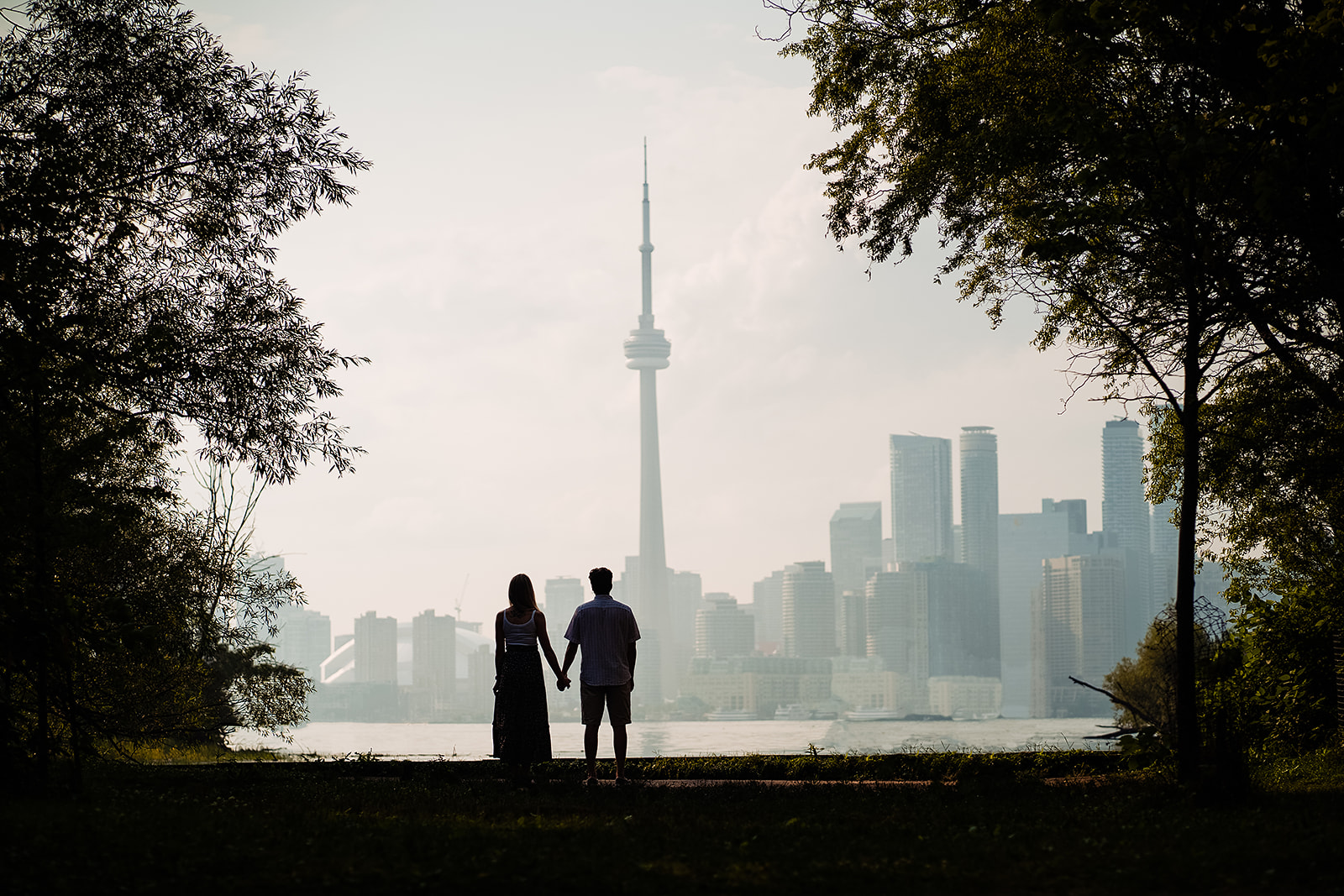 Couple look and CN tower during an engagement session 