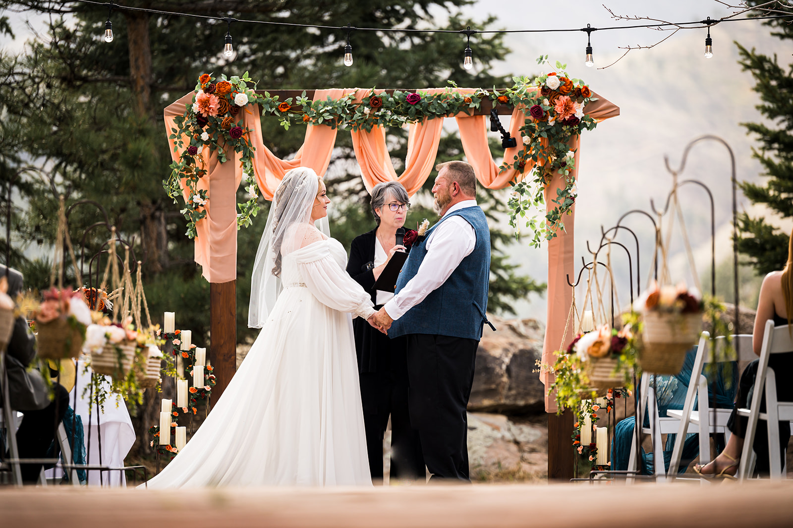 Bride and groom at ceremony Greenbriar Inn Boulder Colorado wedding photographer flowers holding hands