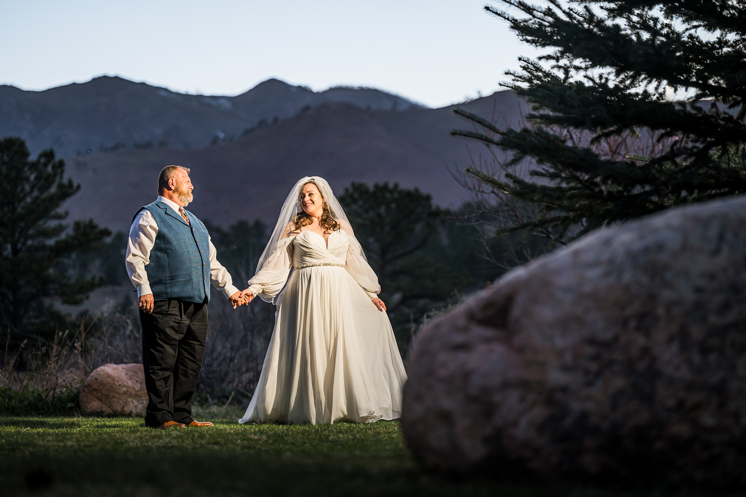 hand and hand walking looking at each other grass rocks mountain blue hour wedding couple photography denver colorado 