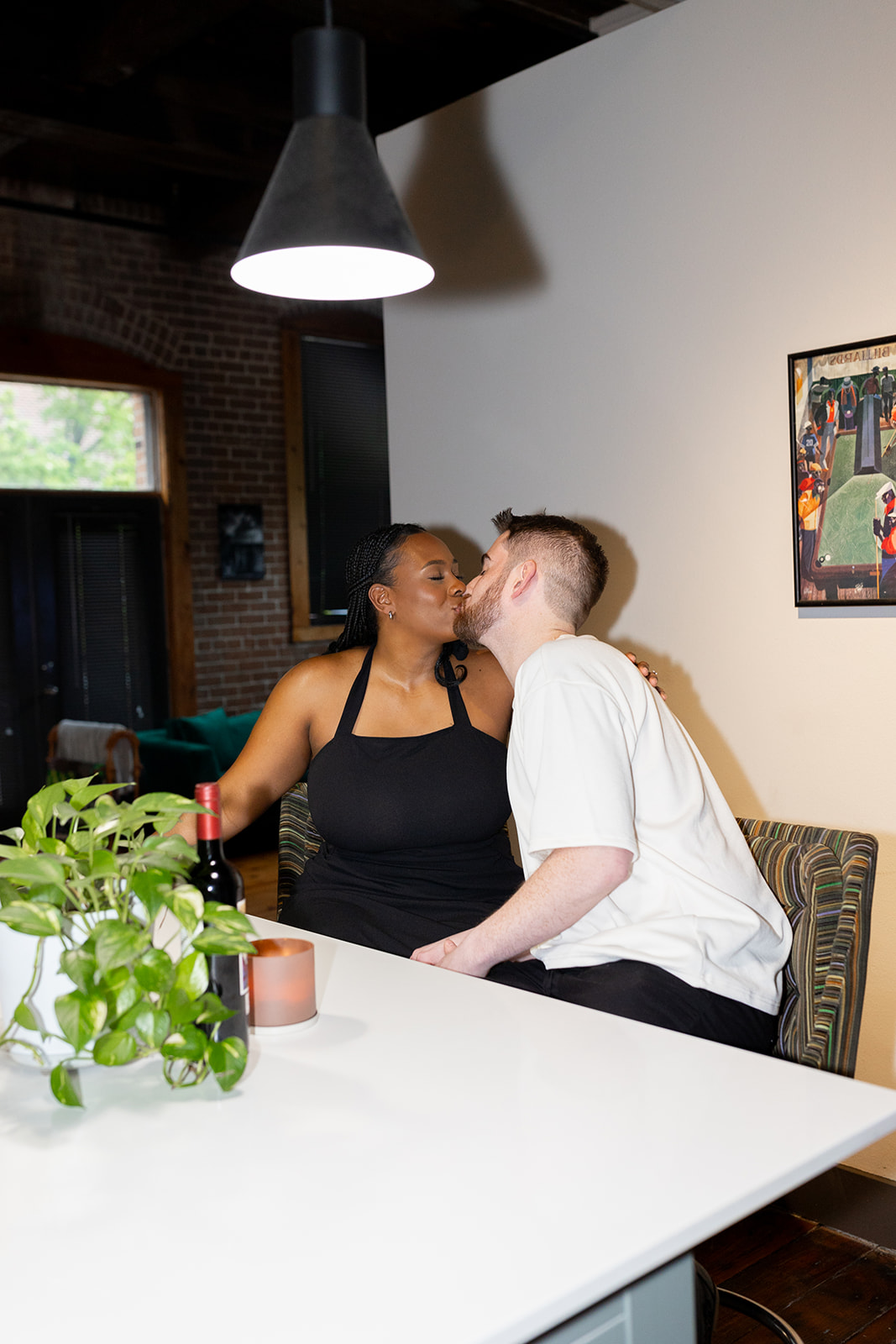 couple kissing in kitchen of their apartment during engagement session